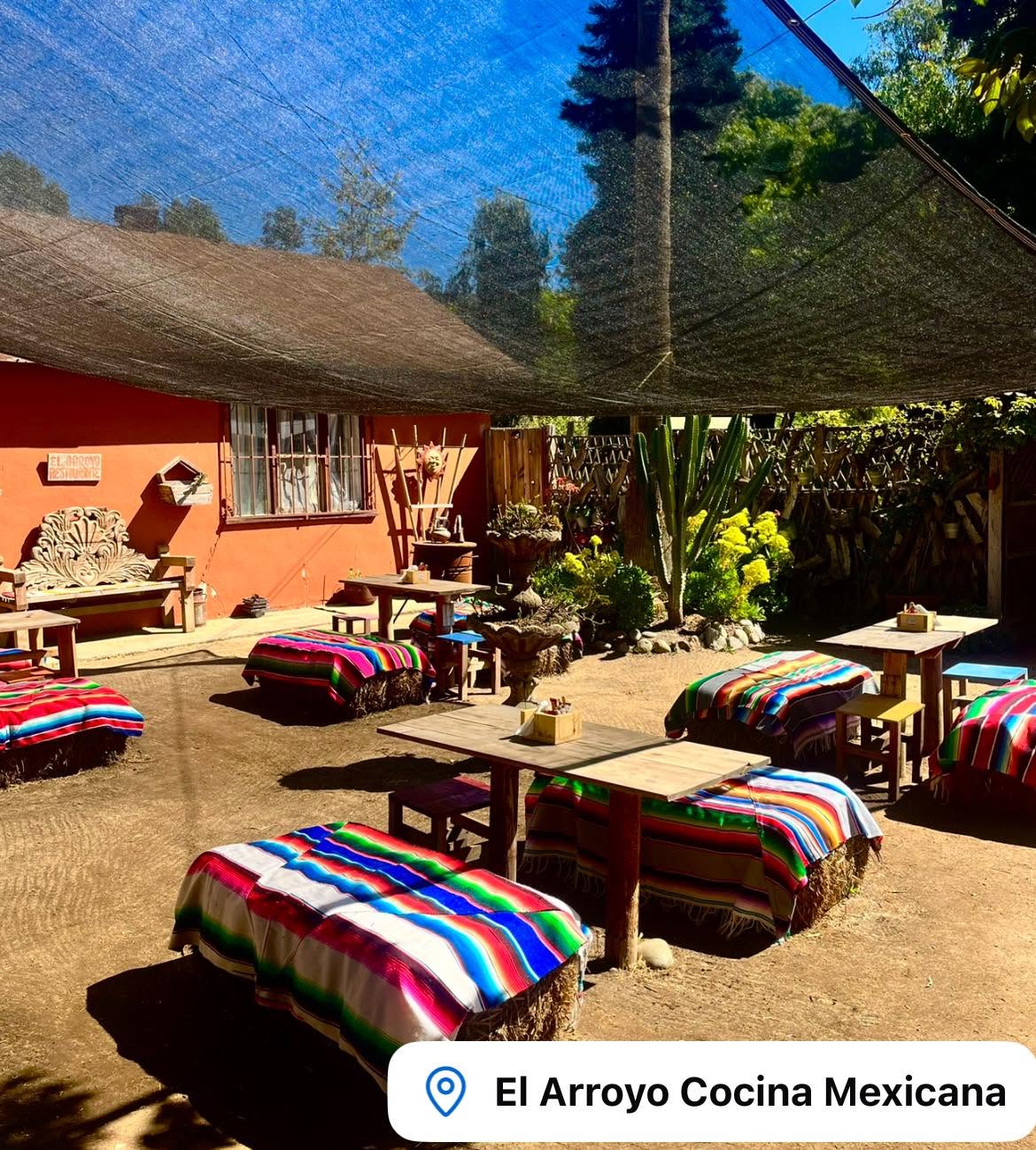 Patio al aire libre con mesas y sarapes
